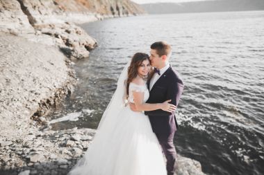 Güzel bir sahilde poz veren genç bir çiftin mutlu ve romantik sahnesi.