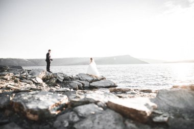 Güzel bir sahilde poz veren genç bir çiftin mutlu ve romantik sahnesi.