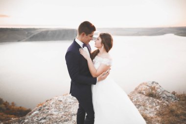 Güzel bir sahilde poz veren genç bir çiftin mutlu ve romantik sahnesi.