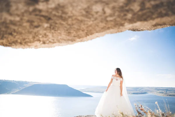 Vacker dam, bruden poserar i en bröllopsklänning nära havet vid solnedgången — Stockfoto