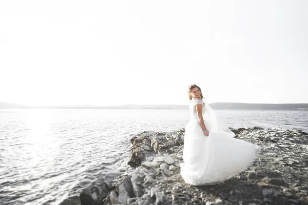 Mooie jonge bruid poseren op de achtergrond-zee — Stockfoto