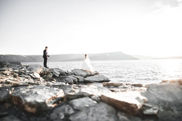 Güzel bir sahilde poz veren genç bir çiftin mutlu ve romantik sahnesi.