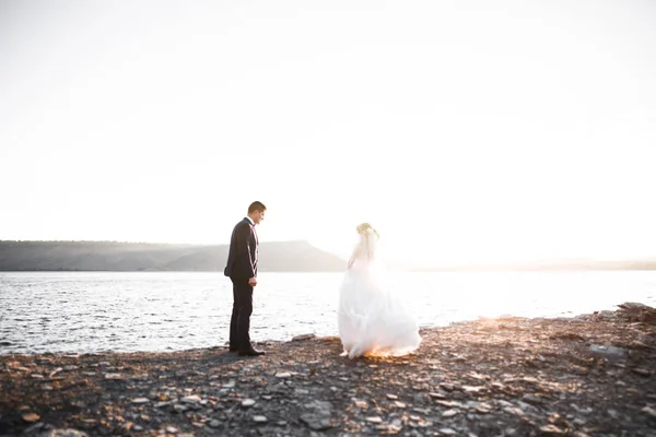 Scena felice e romantica di appena sposati giovani sposi in posa sulla bellissima spiaggia — Foto Stock