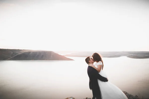 Şık, şık, mutlu bir düğün çifti, gelin, deniz ve gökyüzünün arka planında muhteşem bir damat. — Stok fotoğraf