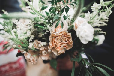 Elinde farklı çiçekler olan güzel bir düğün buketi.