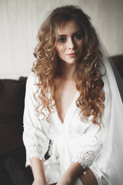 Beyaz elbiseli lüks gelin düğün törenine hazırlanırken poz veriyor.