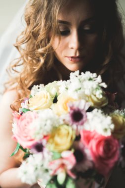 Beyaz elbiseli lüks gelin düğün törenine hazırlanırken poz veriyor.