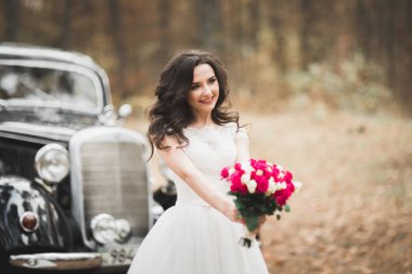 Parkta poz veren zarif beyaz elbiseli güzel gelin.