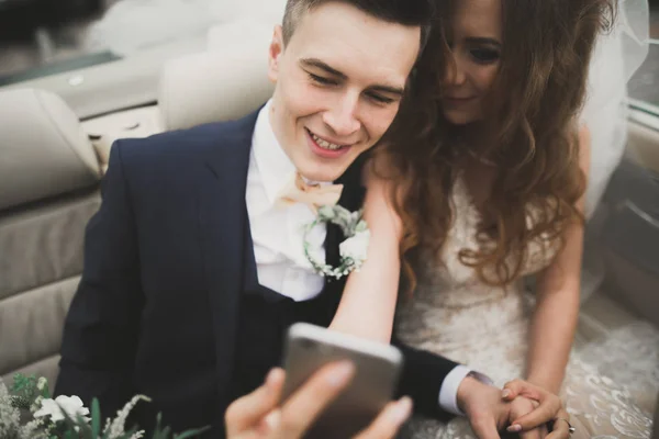 Felice sposo sta prendendo selfie con la sua bella sposa il giorno del matrimonio — Foto Stock