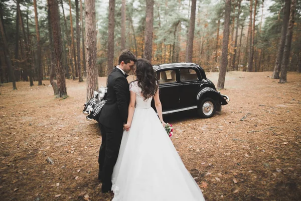 Просто женатая пара в роскошном ретро-автомобиле в день их свадьбы — стоковое фото