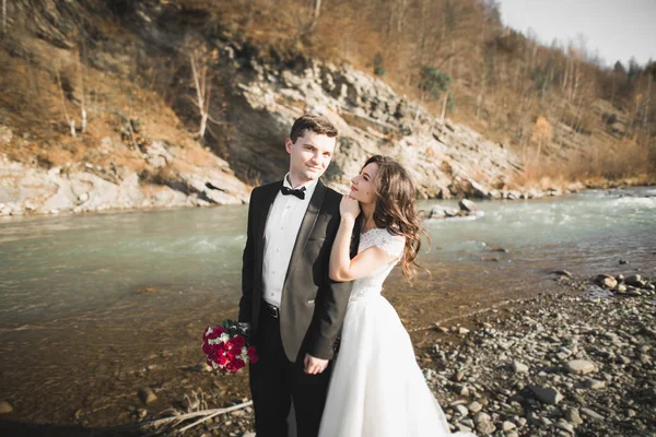 Весільна пара, наречений і наречена обіймаються, на відкритому повітрі біля річки — стокове фото