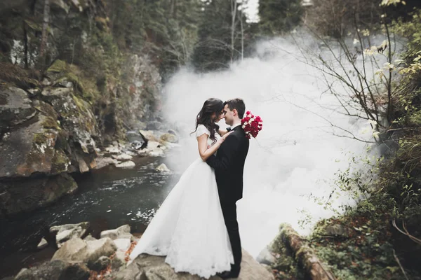 Matrimonio coppia innamorata baciare e abbracciare vicino rocce sul bellissimo paesaggio — Foto Stock