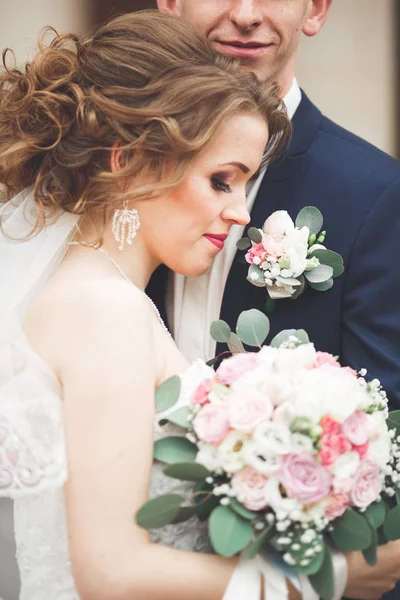 Čerstvě vdaná, svatební pár, pózování a nevěsta drží v ruce kytici — Stock fotografie
