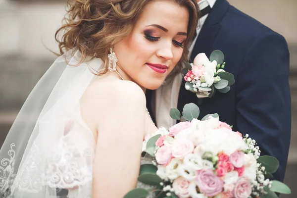 Juste marié couple de mariage posant et mariée tenant dans les mains bouquet — Photo