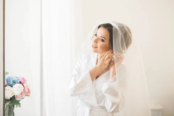 Noiva de luxo em vestido branco posando enquanto se prepara para a cerimônia de casamento — Fotografia de Stock