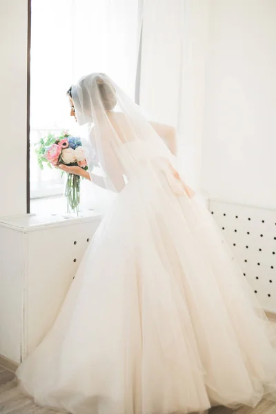 Noiva de luxo em vestido branco posando enquanto se prepara para a cerimônia de casamento — Fotografia de Stock