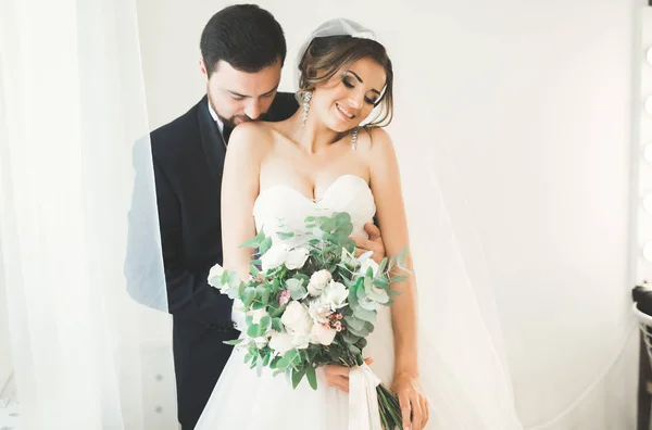 Sessão de fotos de casamento do casal recém-casados em um belo hotel posando perto da janela — Fotografia de Stock