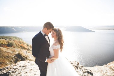 Güzel bir sahilde poz veren genç bir çiftin mutlu ve romantik sahnesi.