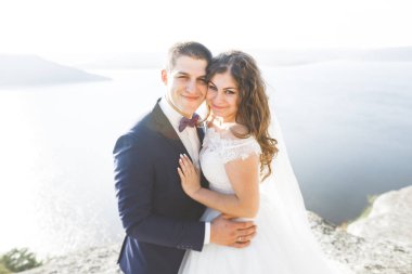 Güzel bir sahilde poz veren genç bir çiftin mutlu ve romantik sahnesi.