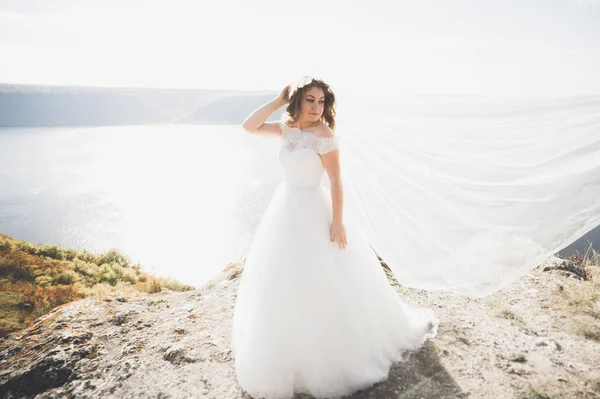 Bella giovane sposa in posa sullo sfondo del mare — Foto Stock