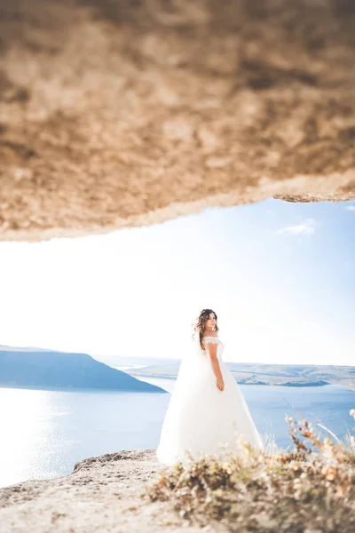 Όμορφη νεαρή νύφη ποζάρει στο παρασκήνιο στη θάλασσα — Φωτογραφία Αρχείου