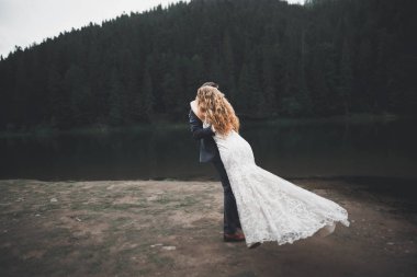 Harika bir gelin damada poz veriyor ve harika manzaralı dağlarda lüks bir tören yapıyor.