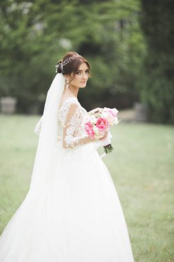 Gelinlik içinde dışarıda poz veren güzel gelin.