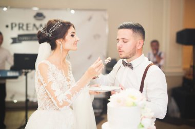 Gelin ve damat düğün pastasını kesiyor.