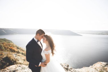 Güzel bir sahilde poz veren genç bir çiftin mutlu ve romantik sahnesi.