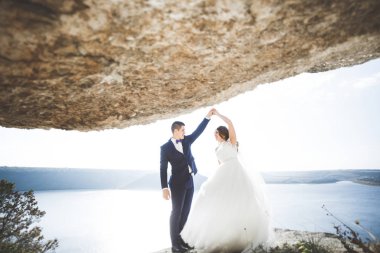 Güzel bir sahilde poz veren genç bir çiftin mutlu ve romantik sahnesi.