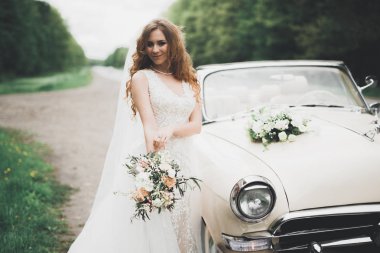 Retro arabanın yakınında açık havada poz güzel bir gelin