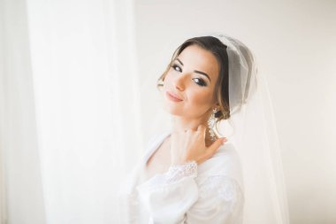 Beyaz elbiseli lüks gelin düğün törenine hazırlanırken poz veriyor.