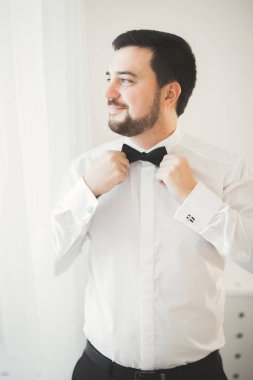 Güzel adam, damat poz veriyor ve düğüne hazırlanıyor.