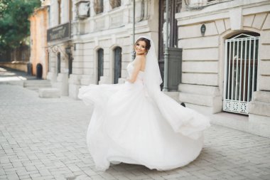 Gelinlik içinde dışarıda poz veren güzel gelin.