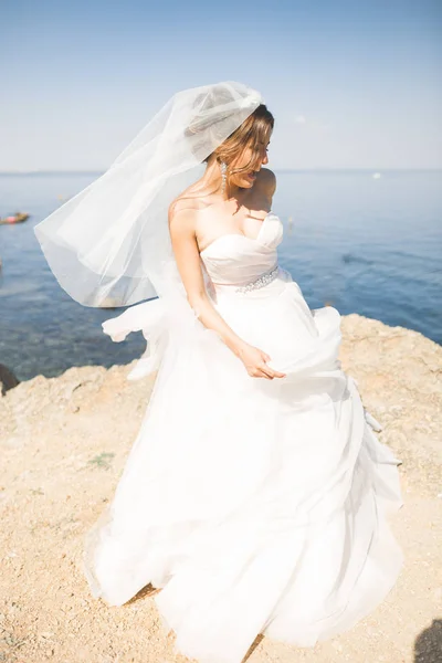 Romantico bella sposa in abito bianco in posa sullo sfondo mare — Foto Stock