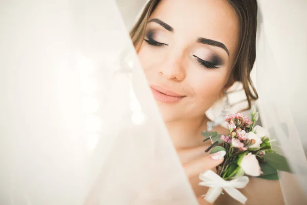 Gyönyörű menyasszony köntösben pózol és készül az esküvői szertartás arc egy szobában — Stock Fotó