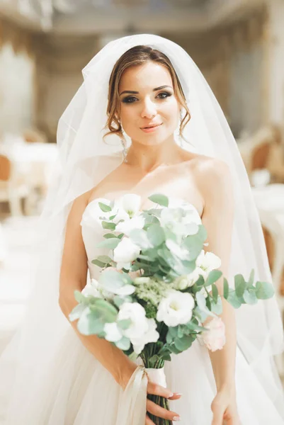 Bella sposa con bouquet da sposa in posa in hotel — Foto Stock