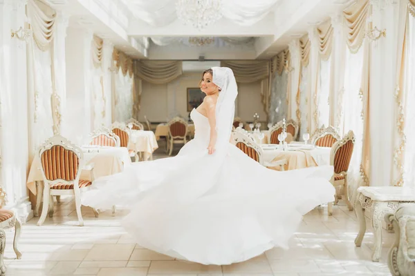 Bela noiva vestindo vestido de noiva de moda com penas com deleite de luxo maquiagem e penteado, estúdio sessão de fotos indoor — Fotografia de Stock