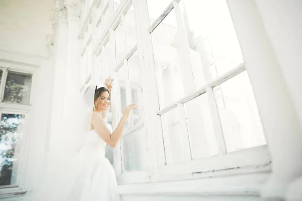 Bella sposa in abito da sposa con gonna lunga completa, sfondo bianco, danza e sorriso — Foto Stock