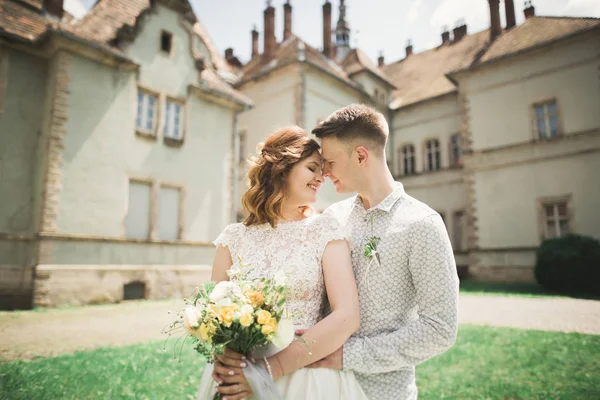 美しいロマンチックな結婚式のカップルの新婚旅行の近くに古い城抱擁 — ストック写真