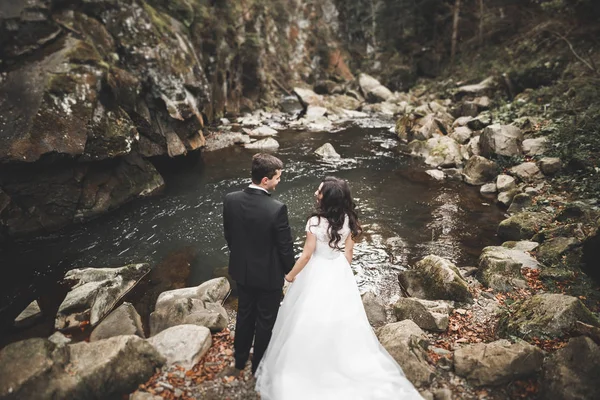 Casamento casal no amor beijando e abraçando perto de pedras na bela paisagem — Fotografia de Stock