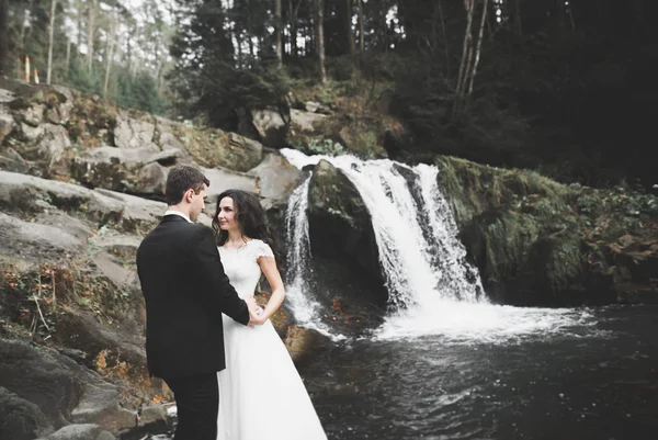 Casamento casal no amor beijando e abraçando perto de pedras na bela paisagem — Fotografia de Stock