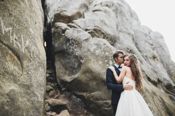 Muhteşem gelin, damat öpüşme ve sarılma Gösterim çarpıcı uçurum yakın: