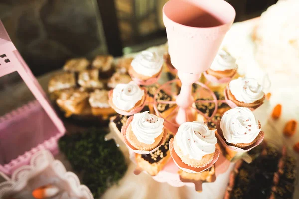 Délicieuse et savoureuse table à dessert avec des petits gâteaux plans à la réception gros plan — Photo