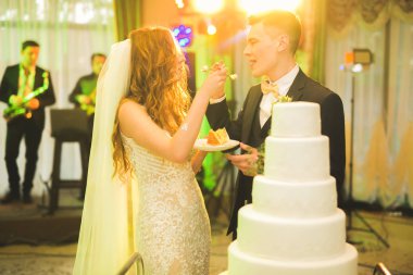 Gelin ve damat düğün pastasını kesiyor.