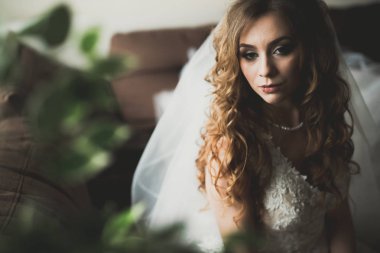 Beyaz elbiseli lüks gelin düğün törenine hazırlanırken poz veriyor.