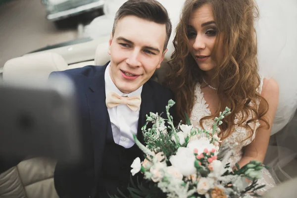 Felice sposo sta prendendo selfie con la sua bella sposa il giorno del matrimonio — Foto Stock