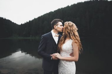 Harika bir gelin damada poz veriyor ve harika manzaralı dağlarda lüks bir tören yapıyor.