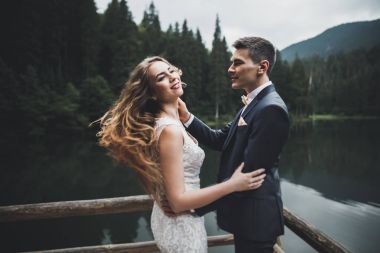 Harika bir gelin damada poz veriyor ve harika manzaralı dağlarda lüks bir tören yapıyor.