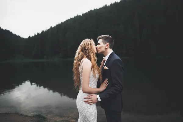 Güzel dağlarda poz veren mutlu bir düğün çifti. — Stok fotoğraf